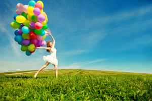 Happy birthday woman against the sky with rainbow-colored air ba